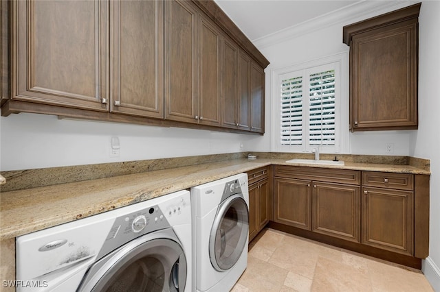 laundry room featuring cabinets, crown molding, independent washer and dryer, and sink