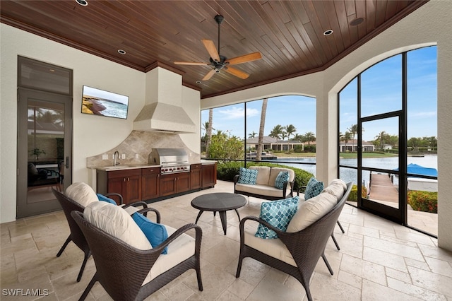 sunroom / solarium with a ceiling fan, wooden ceiling, a water view, and a sink