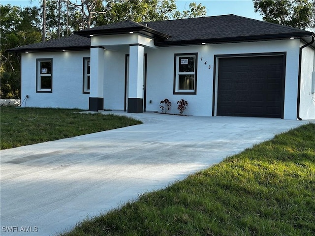 view of front of home featuring a garage and a front lawn