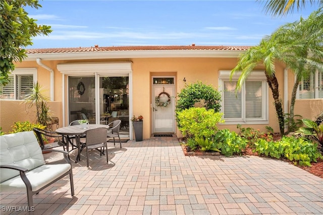 view of exterior entry featuring a patio