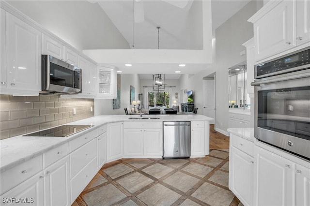 kitchen featuring white cabinetry, kitchen peninsula, sink, and appliances with stainless steel finishes