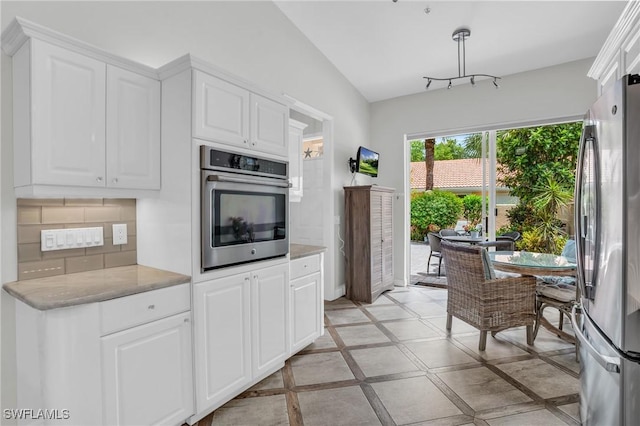 kitchen with backsplash, white cabinets, light tile patterned floors, and appliances with stainless steel finishes