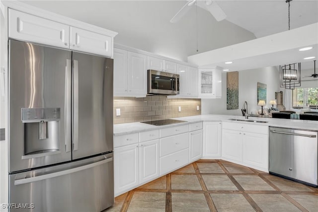 kitchen with decorative backsplash, ceiling fan with notable chandelier, stainless steel appliances, sink, and white cabinetry