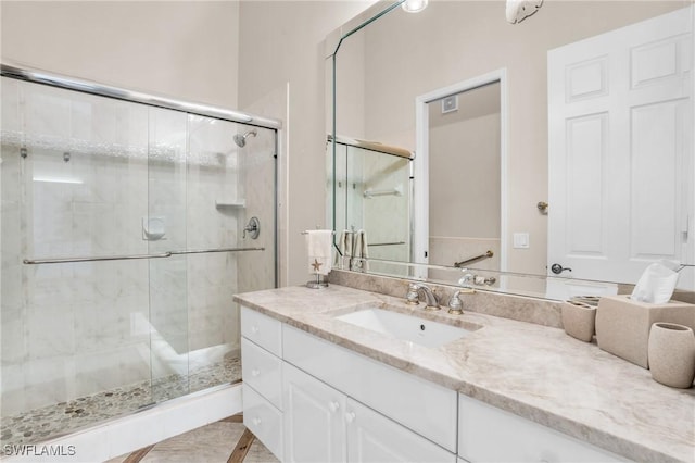 bathroom with tile patterned flooring, vanity, and a shower with shower door