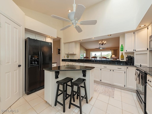 kitchen featuring black appliances, ceiling fan with notable chandelier, dark stone countertops, and white cabinetry