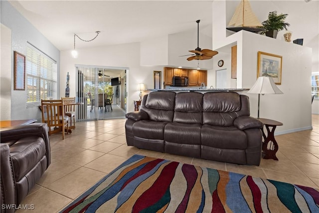 living room with light tile patterned floors, high vaulted ceiling, and ceiling fan