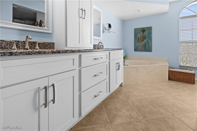 bathroom featuring vanity, a tub to relax in, and tile patterned floors