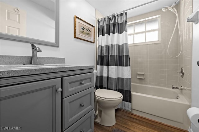 full bathroom featuring hardwood / wood-style floors, vanity, shower / tub combo, and toilet