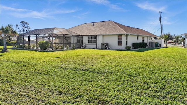 back of property featuring a lanai and a lawn