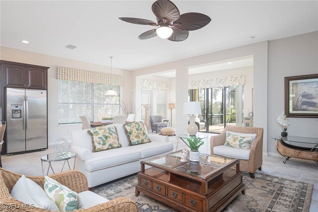 tiled living room with ceiling fan and a healthy amount of sunlight