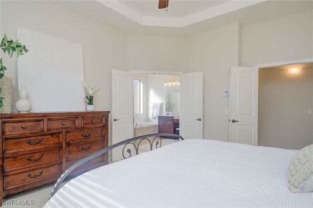 bedroom featuring a tray ceiling, light carpet, and ceiling fan