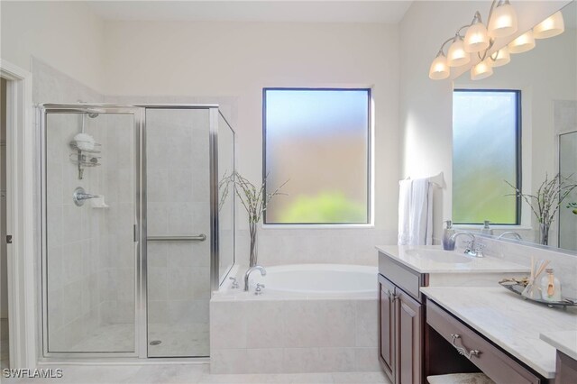 bathroom with vanity, independent shower and bath, and a chandelier