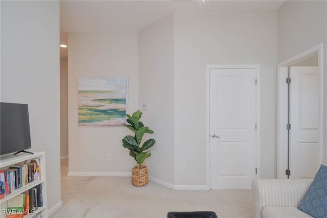 living area featuring carpet and baseboards
