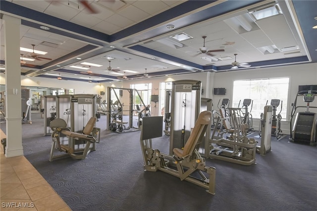 exercise room featuring dark colored carpet, a drop ceiling, and ceiling fan