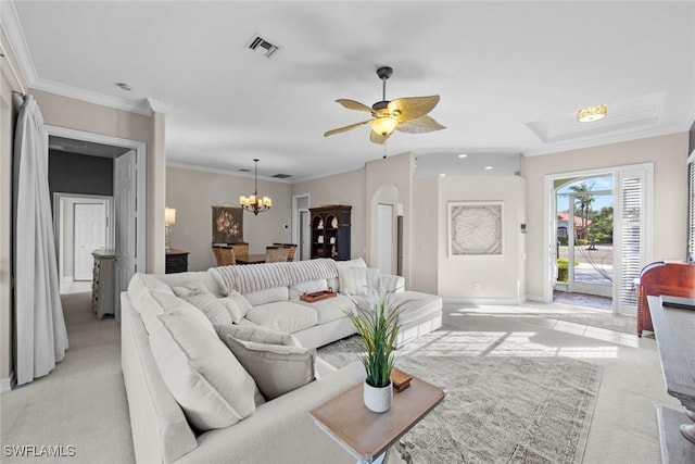 carpeted living room with ceiling fan with notable chandelier and ornamental molding