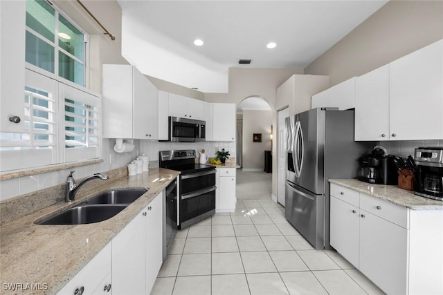 kitchen featuring white cabinetry, sink, light stone counters, and appliances with stainless steel finishes