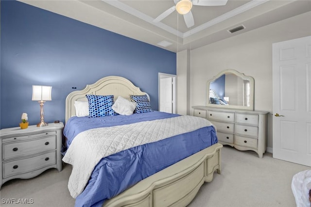 carpeted bedroom with a raised ceiling and ceiling fan