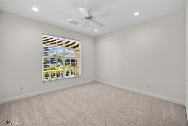 carpeted spare room featuring ceiling fan