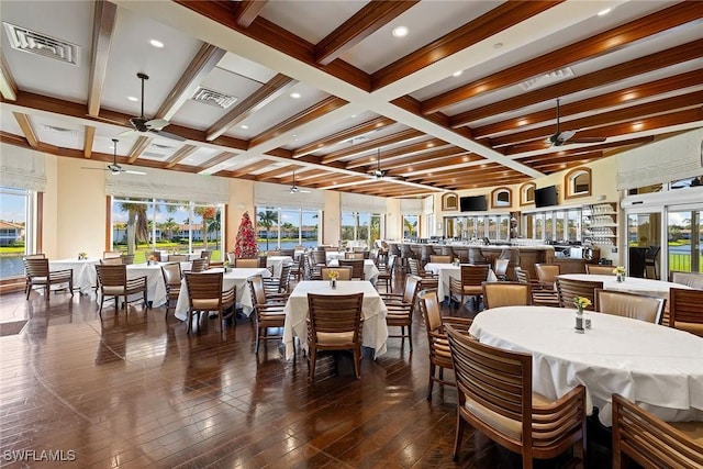 dining area with ceiling fan, beam ceiling, dark wood-type flooring, and coffered ceiling