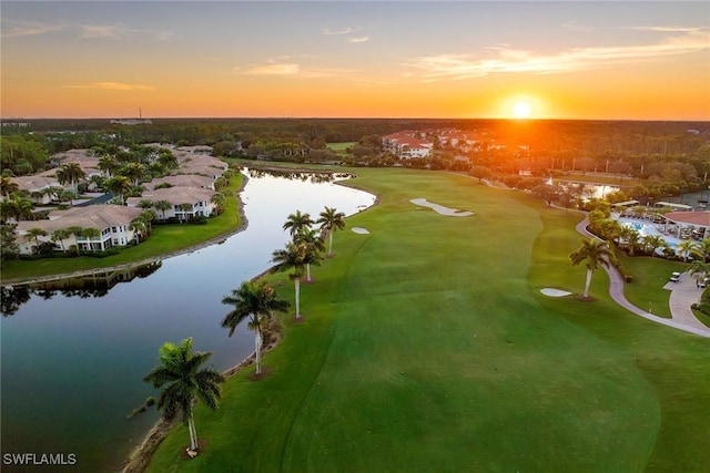 aerial view at dusk featuring a water view