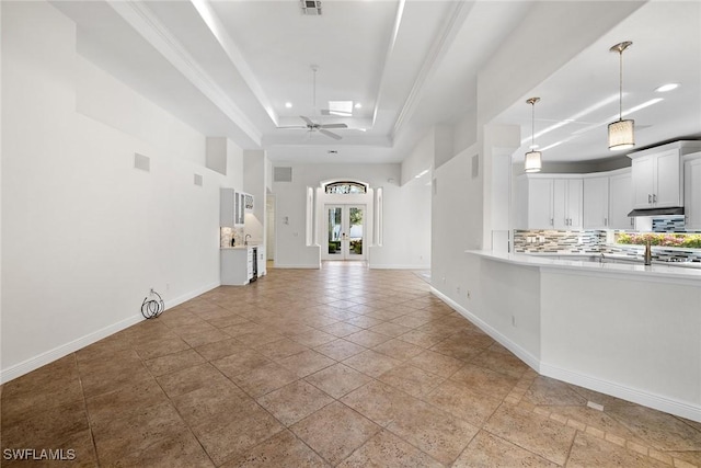 interior space featuring ceiling fan and a raised ceiling