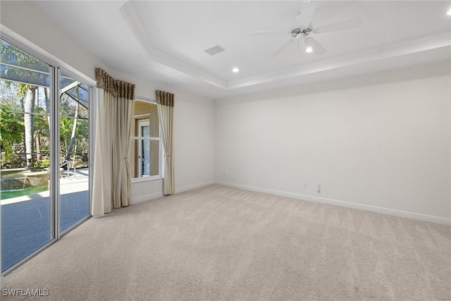 carpeted empty room featuring a raised ceiling, ceiling fan, and ornamental molding