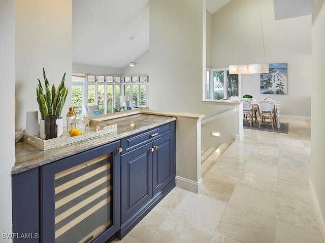 bar featuring blue cabinetry, wine cooler, ceiling fan, and high vaulted ceiling