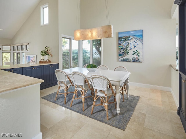 dining space with plenty of natural light and a towering ceiling