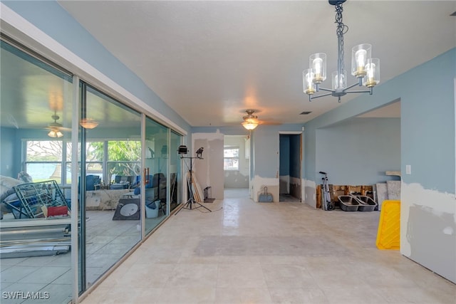 interior space with ceiling fan with notable chandelier