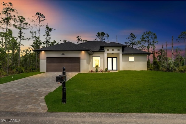 prairie-style home featuring a yard and a garage