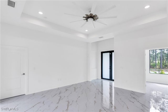 spare room featuring a raised ceiling, ceiling fan, and french doors