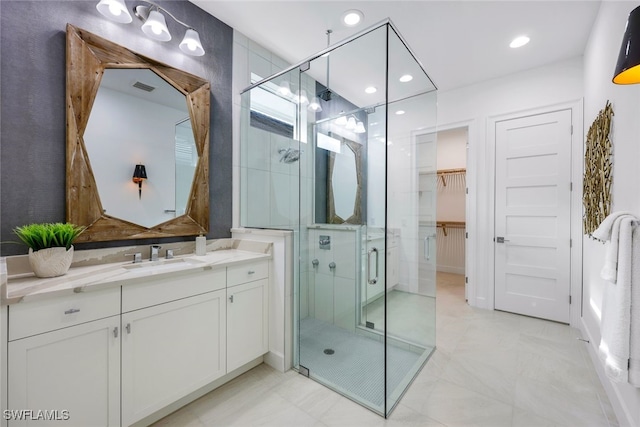 full bath with recessed lighting, vanity, visible vents, a stall shower, and a walk in closet