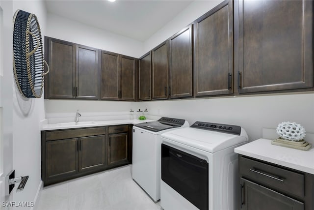 laundry area featuring washer and clothes dryer, a sink, and cabinet space