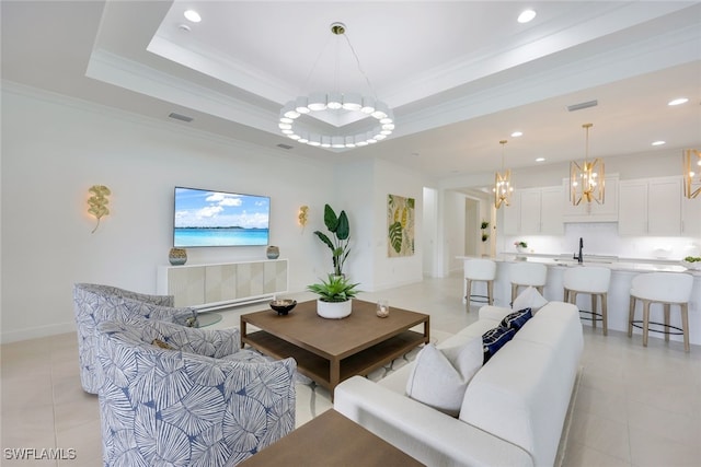 living area featuring a tray ceiling, visible vents, and crown molding