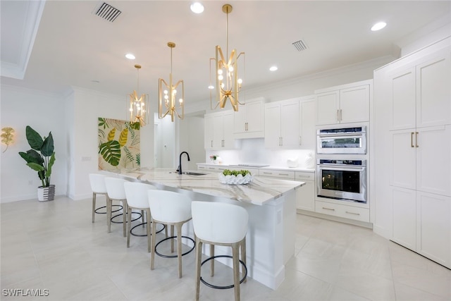 kitchen with ornamental molding, stainless steel double oven, visible vents, and a sink