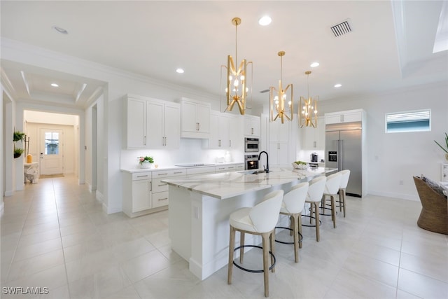 kitchen with visible vents, appliances with stainless steel finishes, a kitchen breakfast bar, and crown molding