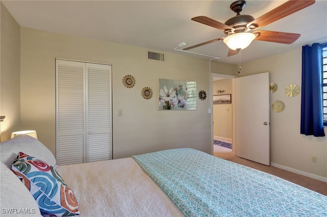 carpeted bedroom with ceiling fan and a closet