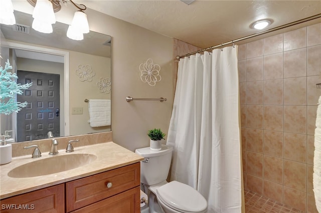 bathroom with a shower with curtain, vanity, a textured ceiling, and toilet