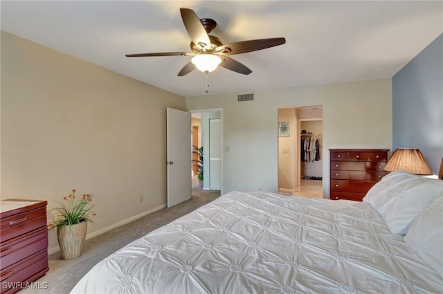 carpeted bedroom featuring ceiling fan, a spacious closet, and a closet