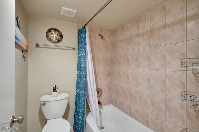 bathroom featuring shower / tub combo with curtain and toilet