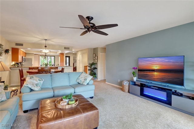 living room with light carpet and ceiling fan with notable chandelier