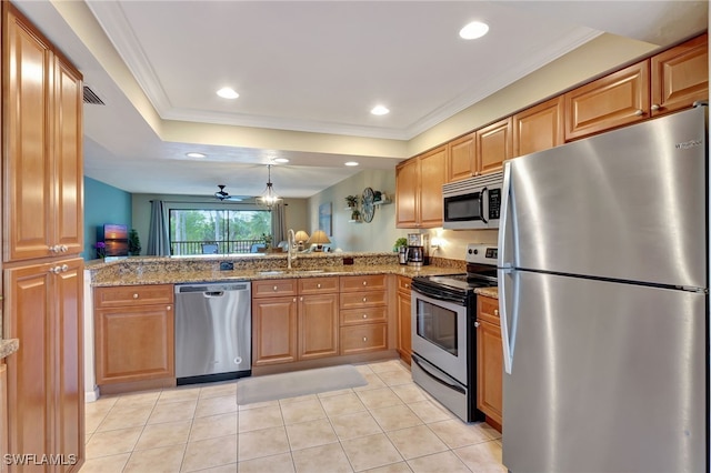 kitchen featuring kitchen peninsula, light stone counters, stainless steel appliances, ceiling fan, and sink