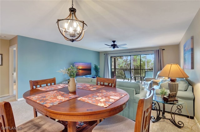 carpeted dining space with ceiling fan with notable chandelier