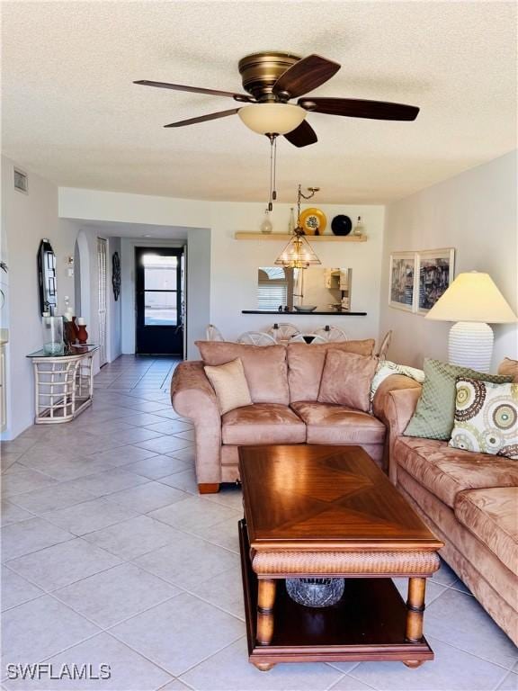 tiled living room featuring ceiling fan and a textured ceiling