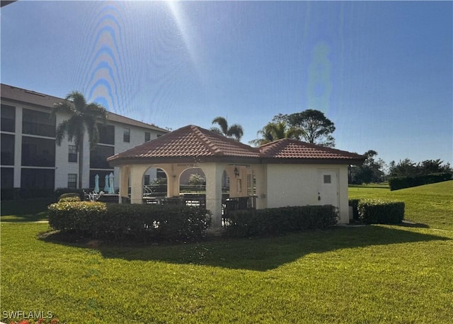 back of house with a gazebo and a yard