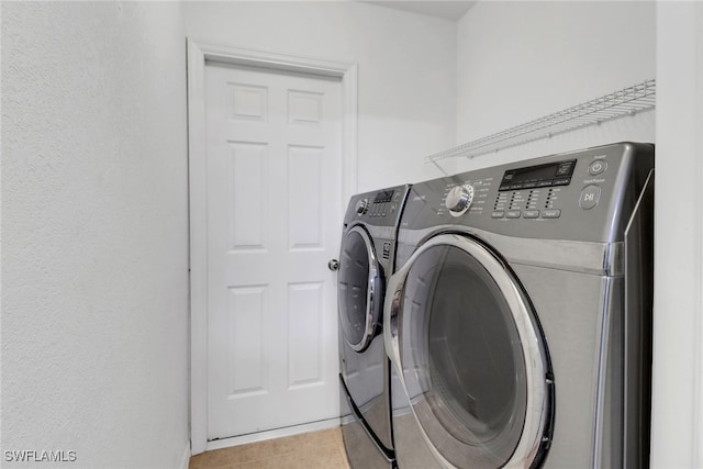 clothes washing area featuring separate washer and dryer and light tile patterned floors