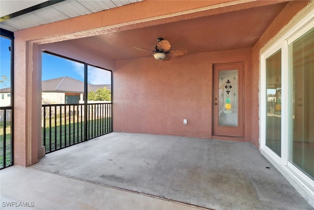 unfurnished sunroom with ceiling fan