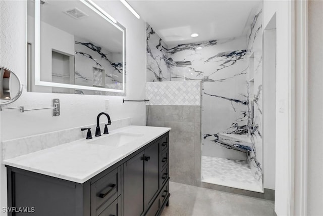 bathroom with vanity and tiled shower