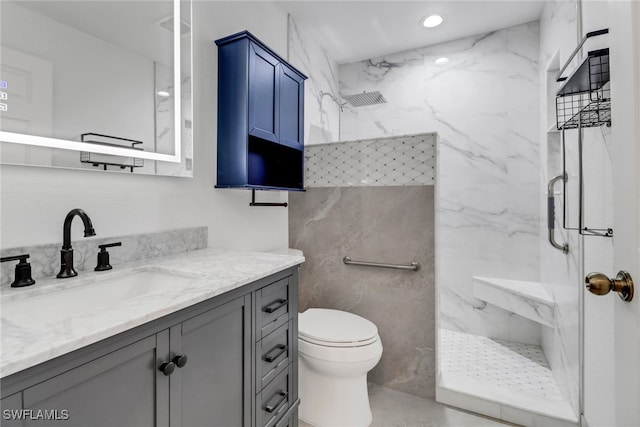 bathroom featuring tiled shower, vanity, and toilet