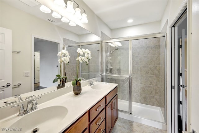 full bath with double vanity, a sink, visible vents, and a shower stall